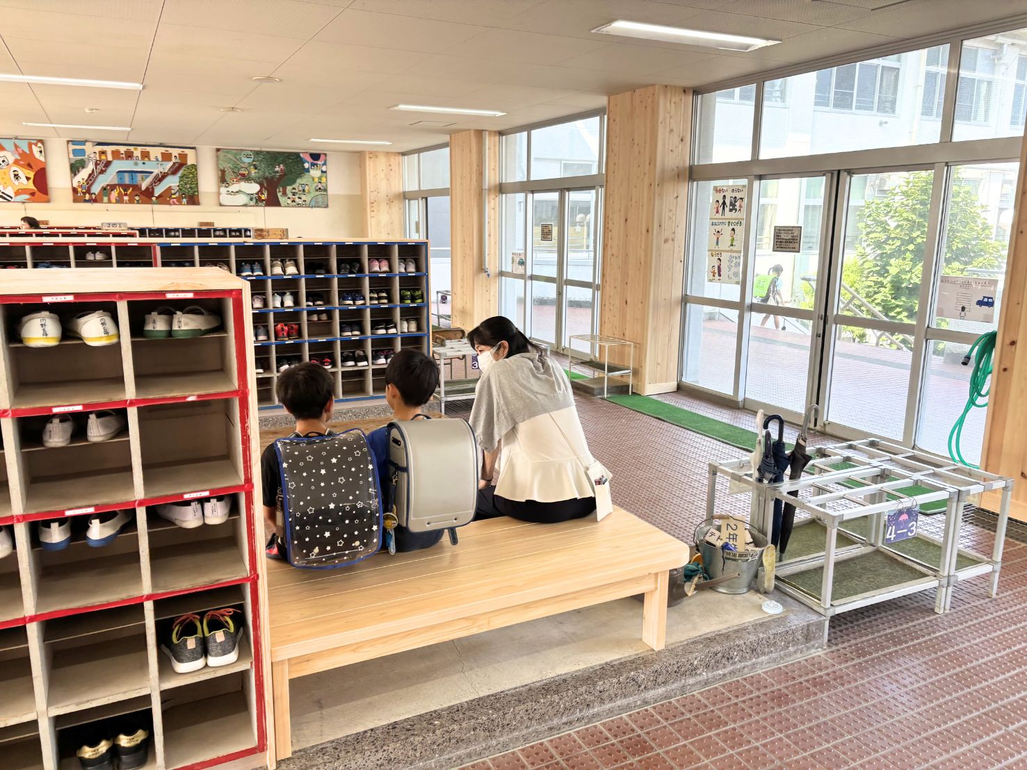 昇降口のベンチに座る先生と生徒の写真